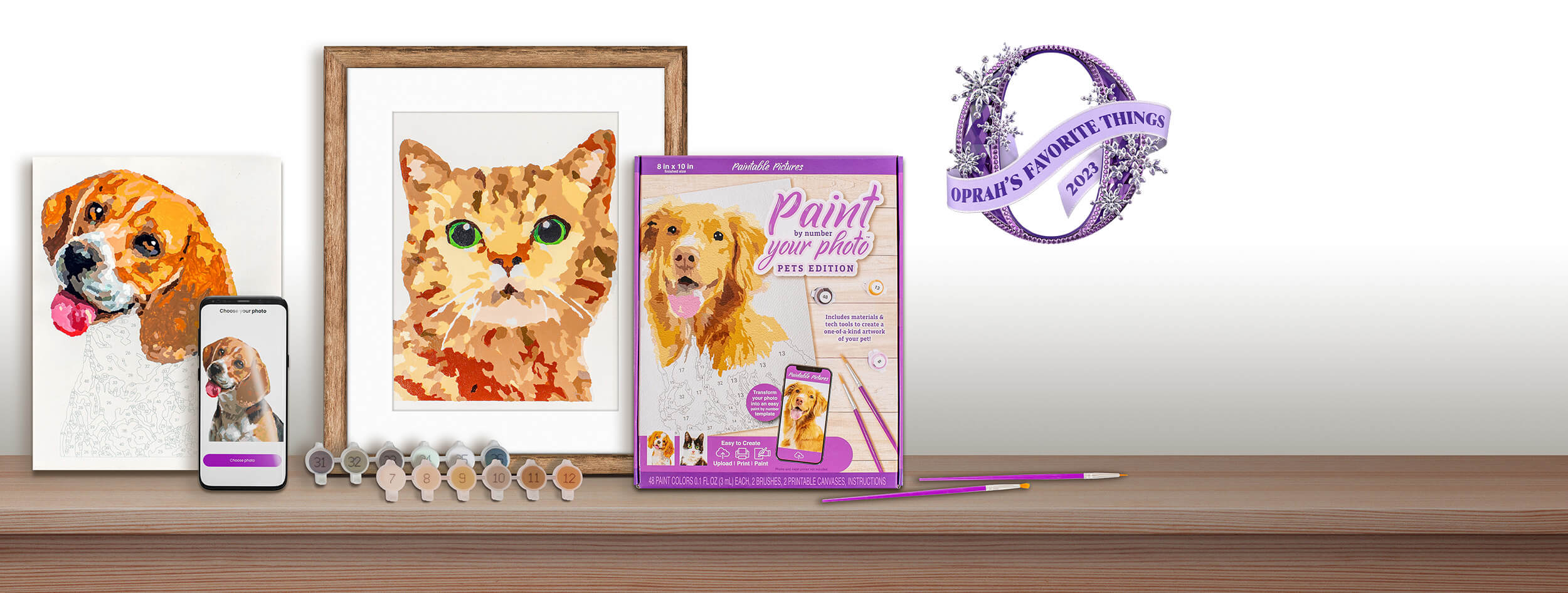 Custom paint by number set featuring a dog portrait, a cat portrait, and a packaged kit with 'Paint Your Photo - Pets Edition' label. The set includes a mobile screen previewing the dog photo, color-coded paints, brushes, and instructions.