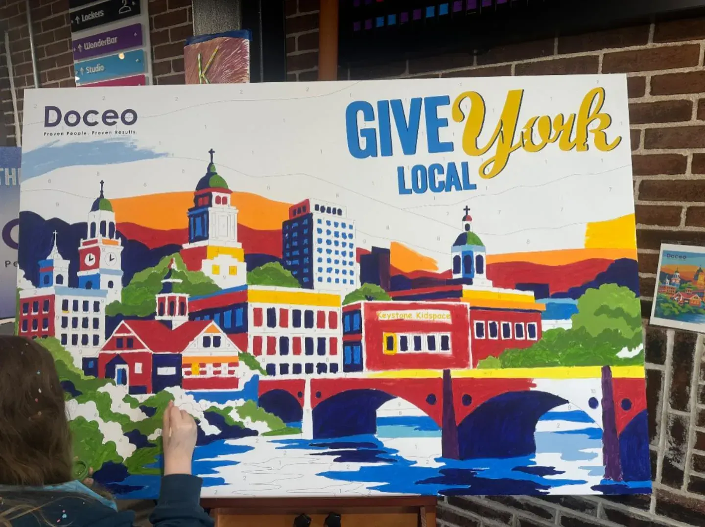 Completed Give Local York paint-by-number mural featuring local buildings and a river scene