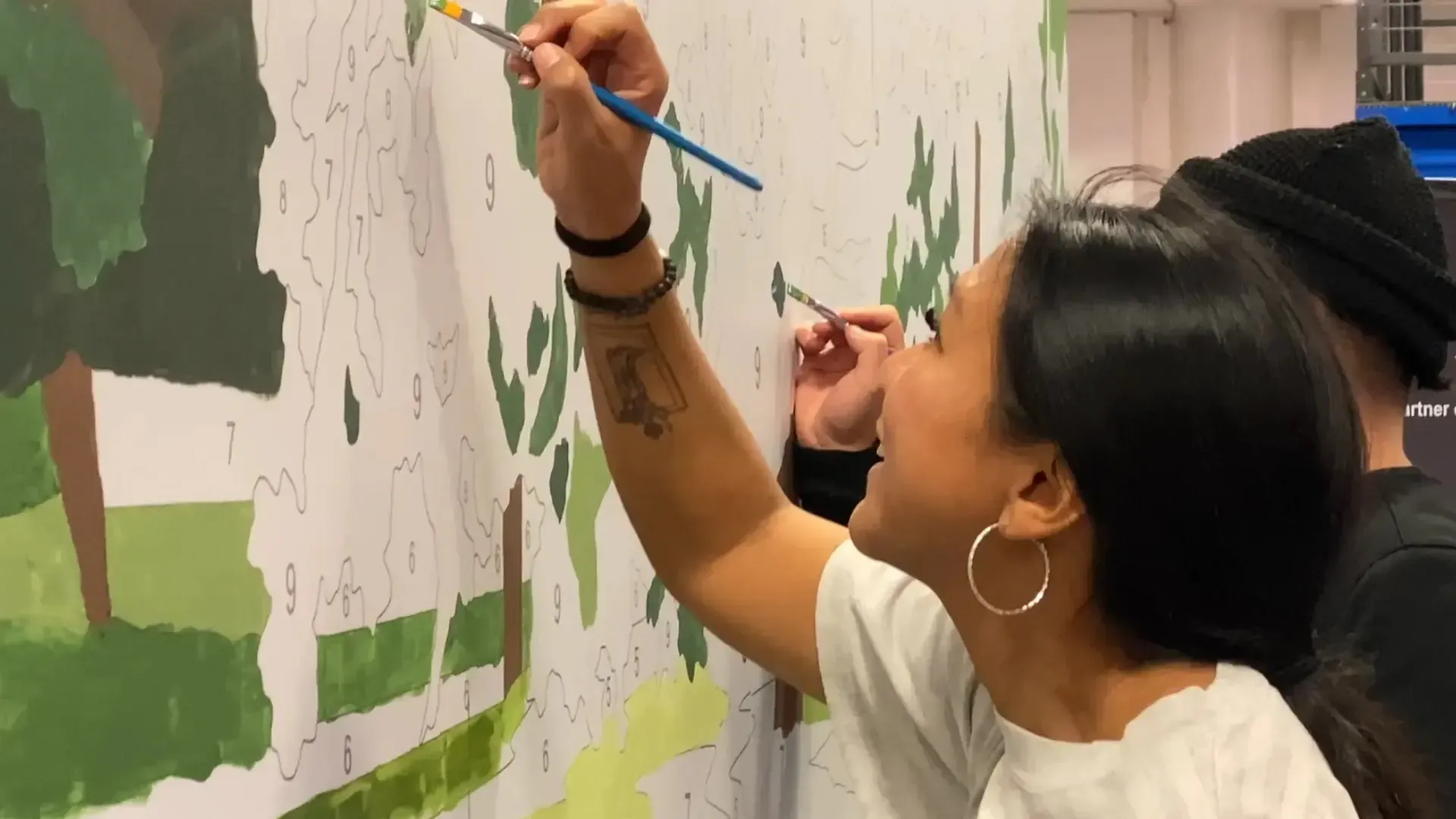 Guests painting a custom paint-by-number mural together at a live event