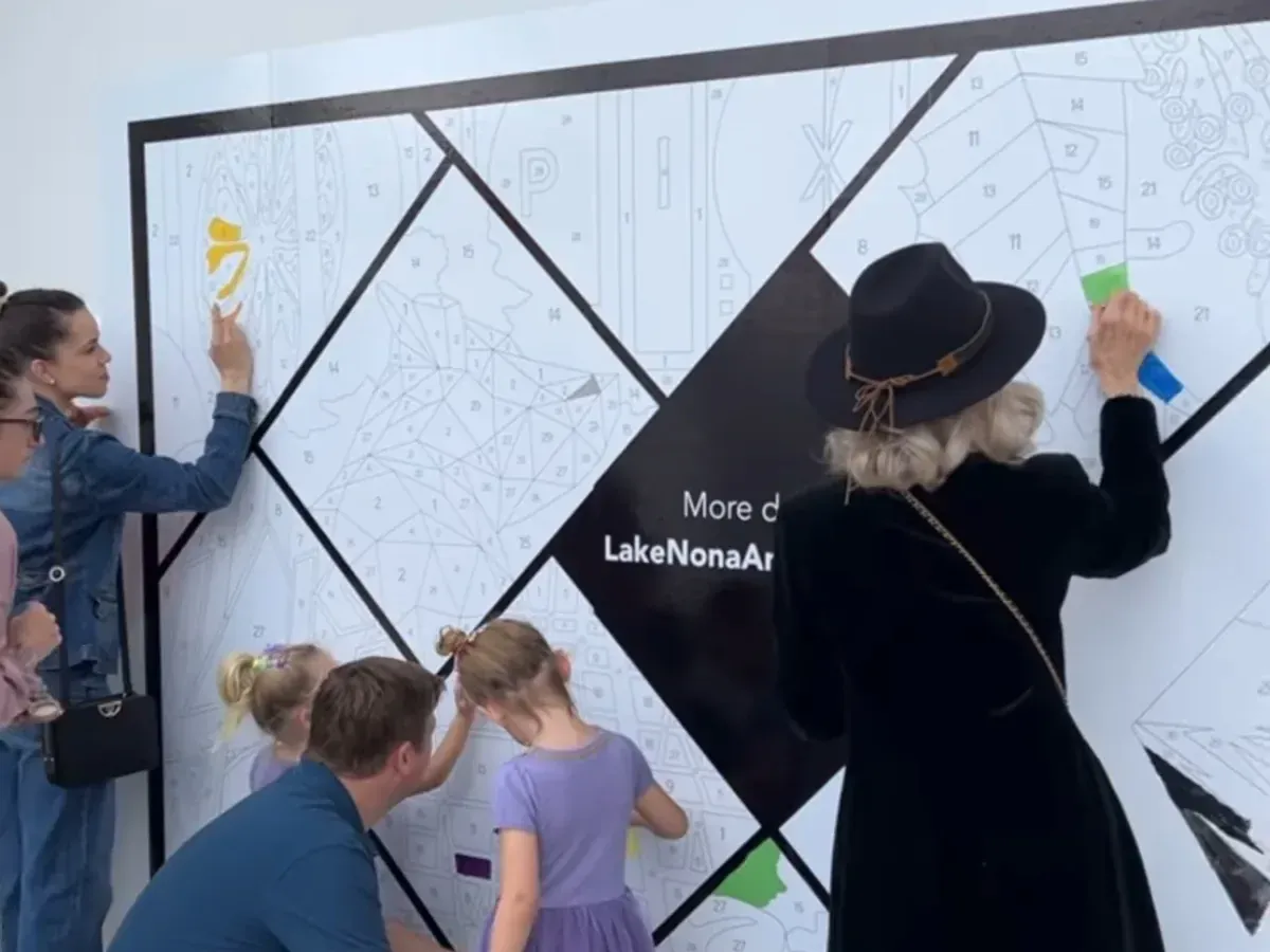 Adults and children painting the Lake Nona Art Festival paint-by-number mural together