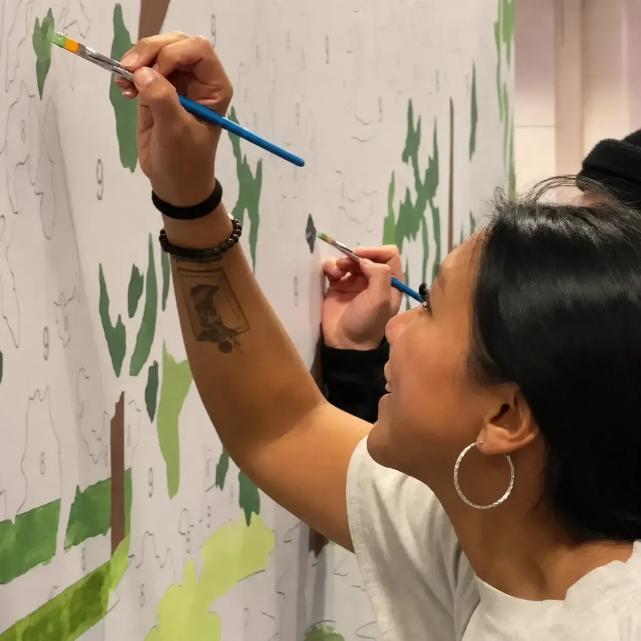 Close-up of fans painting numbered sections of the Novartis paint-by-number mural