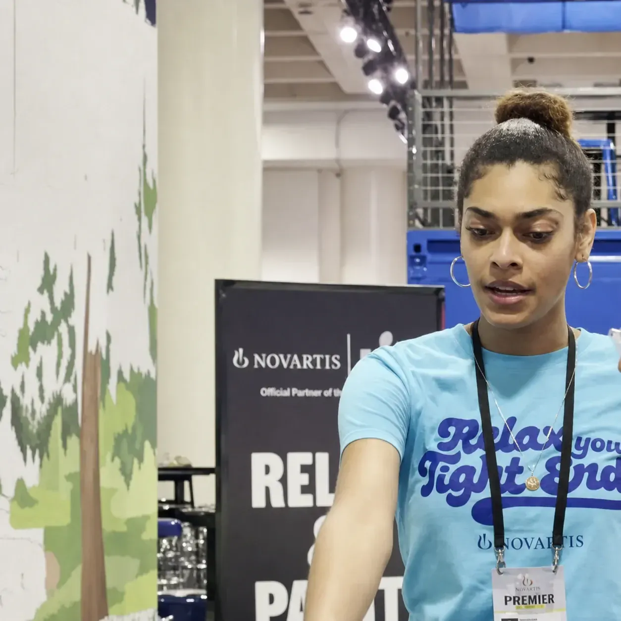 Relax Your Tight End event team member beside the Novartis paint-by-number mural activation